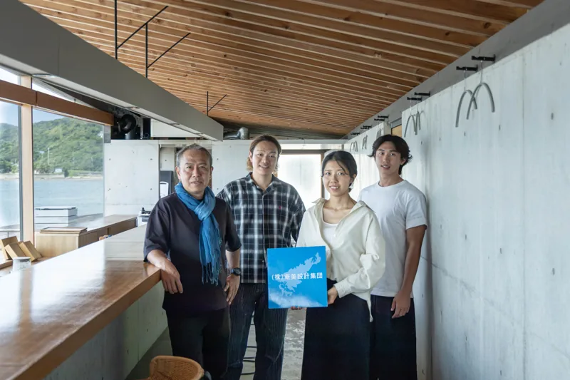 建築模型を手に集合する天工人のスタッフ